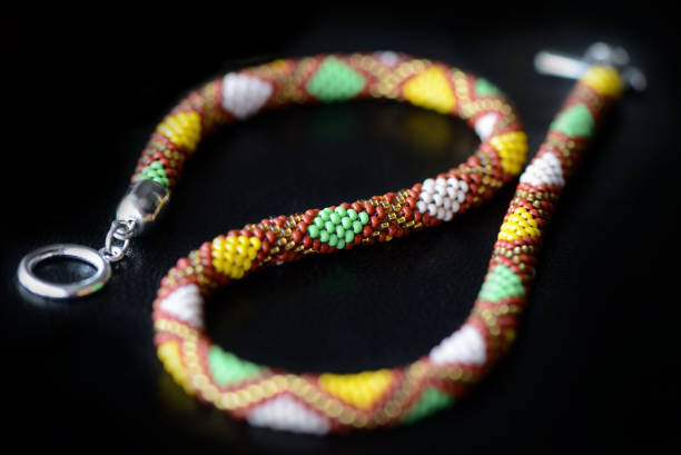istock Beaded necklace with geometry print on a dark background close up 1135450784