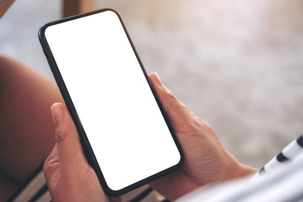 istock Mockup image of woman's hands holding black mobile phone with blank white screen in cafe 1135456741