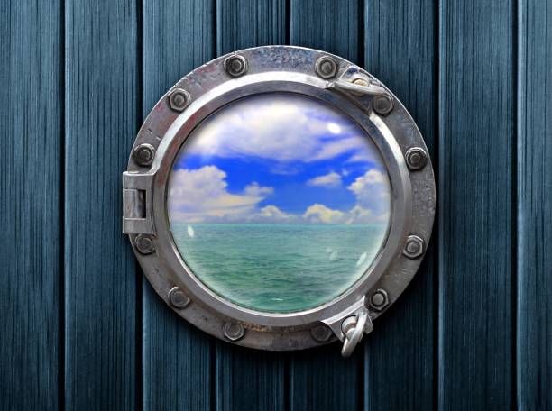 istock Ship porthole with wooden wall and ocean view 1135459078