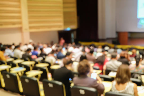 blurred focus group of student sitting for listening teacher explaining or sharing experience and knowledge in convention hall room , education concept blurred focus group of student sitting for listening teacher explaining or sharing experience and knowledge in convention hall room , education concept audience in lecture hall stock pictures, royalty-free photos & images