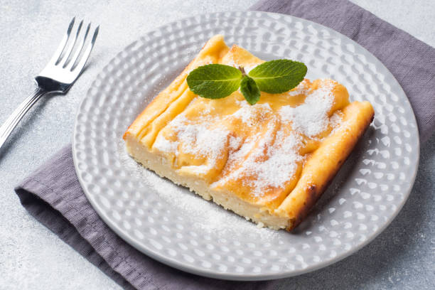 istock Cottage cheese casserole on a plate with powdered sugar and mint leaves. Selective focus 1135463641