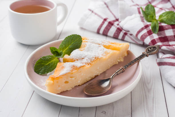 Cottage cheese casserole on a plate with powdered sugar and mint leaves. Selective focus
