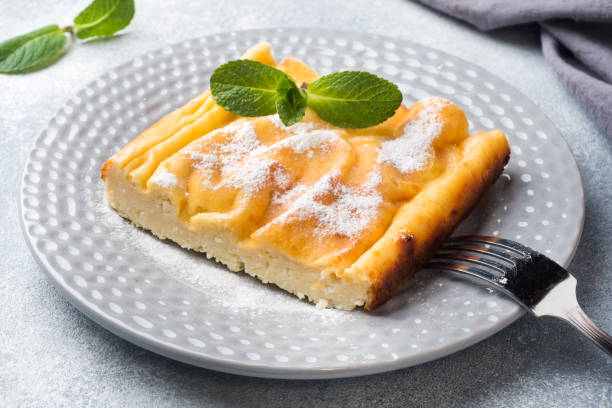 istock Cottage cheese casserole on a plate with powdered sugar and mint leaves. Selective focus 1135463891
