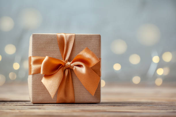 istock Gift box wrapped with craft paper and bow on neutral background with boke. 1135468658
