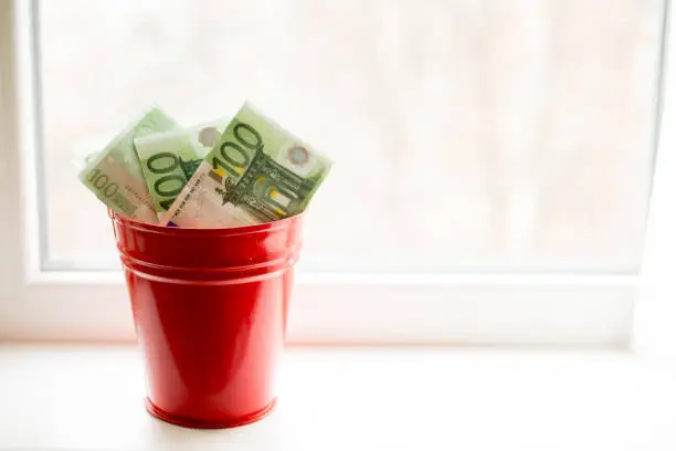 Moneybox, Euro bill in bucket on white window.light background. place for text. top view. a lot of money