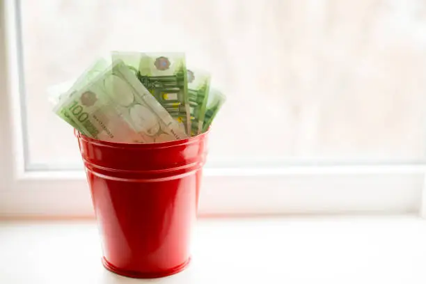 Moneybox, Euro bill in bucket on white window.light background. place for text. top view. a lot of money