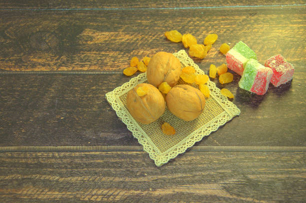 istock Three walnuts, white raisins and Turkish delight, lie on a wooden table. Still life. 1135469145