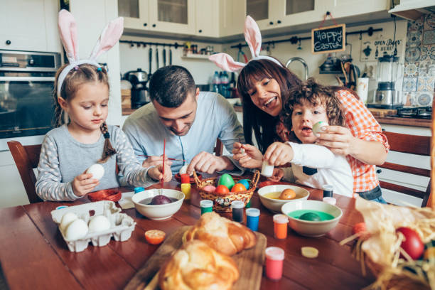 istock Happy family painting Easter eggs 1135470091