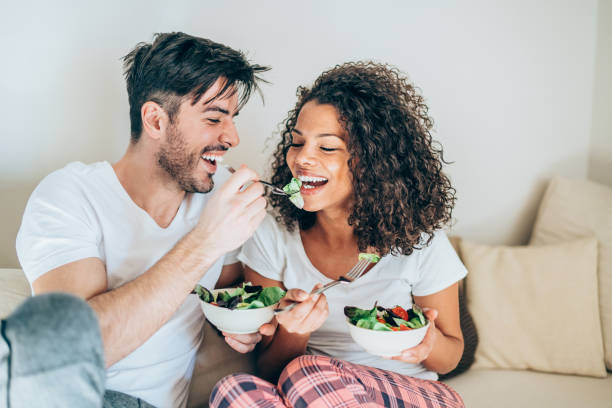 istock Young happy man feeding his girlfriend with salad. 1135470364