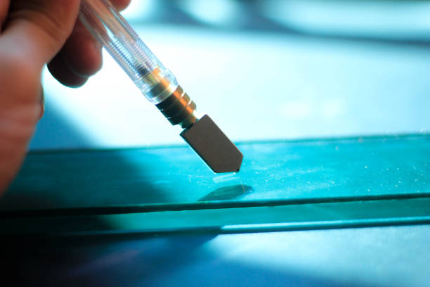 istock glazier is cutting the glass and the reflective sheet. 1135473761