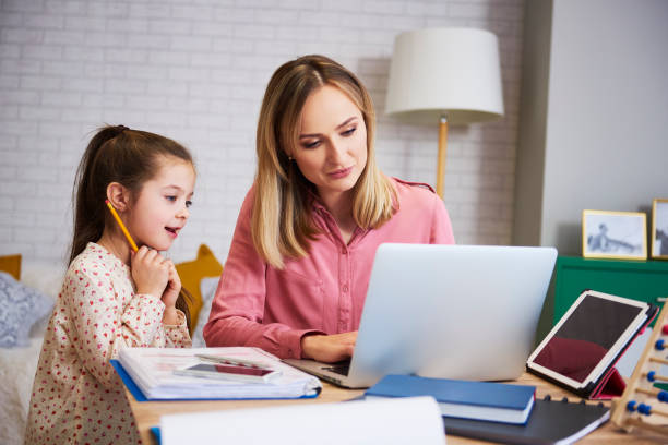 giovane madre che lavora da casa con la figlia - home schooling foto e immagini stock