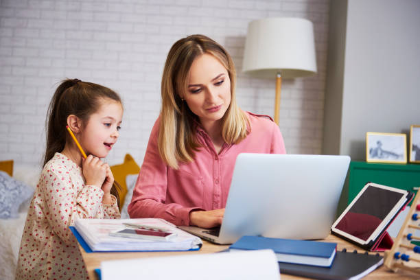 Young mother working from home with daughter Young mother working from home with daughter homeschooling photos stock pictures, royalty-free photos & images