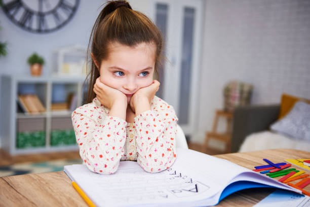 istock Bored and sad girl doing homework at home 1135475041