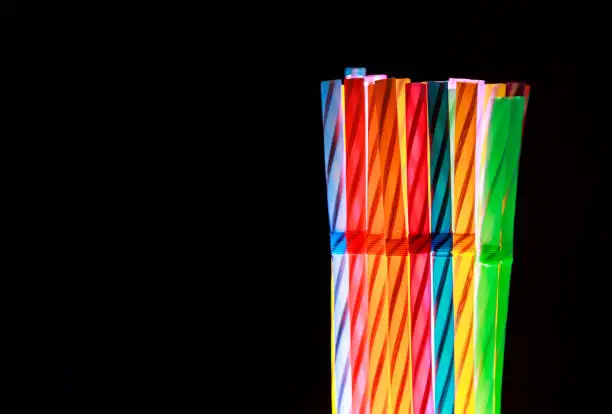 Colorful drinking straws on black background