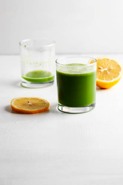 grüner smoothie mit antioxidantien, orangensaft, entgiftungssaft - cold pressed stock-fotos und bilder