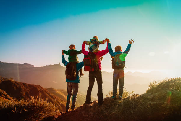 happy family travel in mountains at sunset stock photo