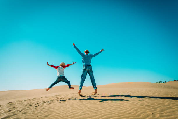happy father and son having fun in sand dunes, family enjoy vacation