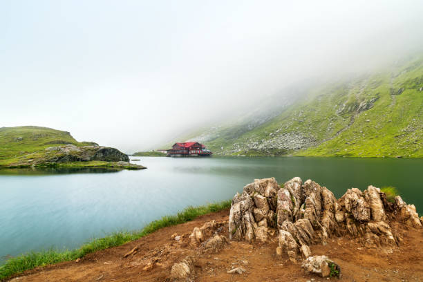 ледниковое озеро туманное утро. озеро балеа, румыния - alpin стоковые фото и изображения