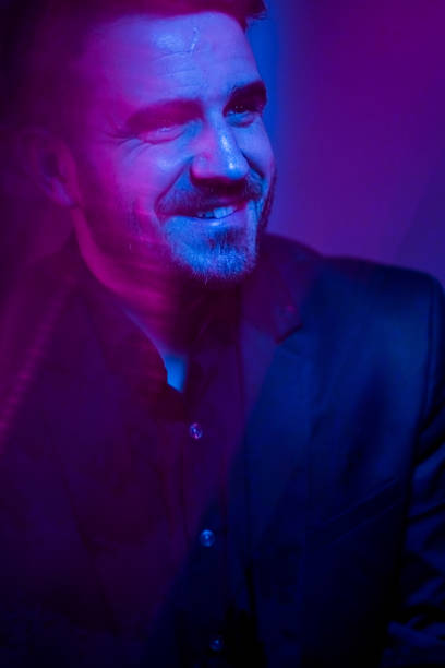 istock Cheerful man in purple light 1135479658