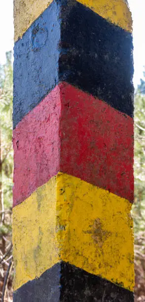 Historical black-red-golden border post at the former border between the German Democratic Republic (GDR) and the Federal Republic of Germany (FRG), close-up view