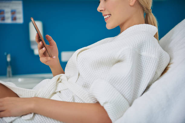 istock Joyful young woman using cellphone in beauty salon 1135483942