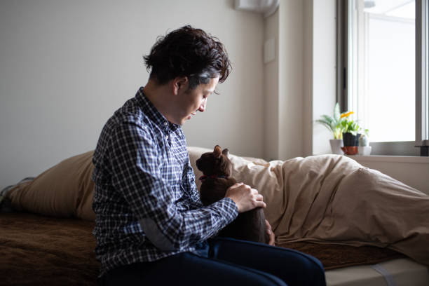 istock Man embracing cat in sleeping room 1135484280