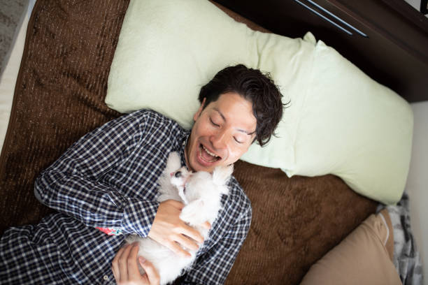 istock Man embracing puppy on bed 1135484339