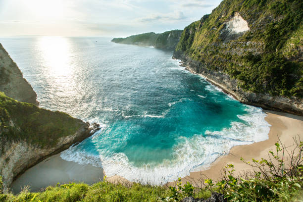 Curve beach line and blue crystal clear water at Nusa Penida Bali, Indonesia This is Kelingking Beach located in Nusa Penida Island, Bali Indonesia. One of the most famous beach at Nusa Penida. kelingking beach stock pictures, royalty-free photos & images