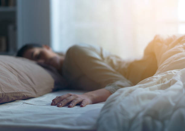istock Young woman sleeping in her bed alone 1135485662