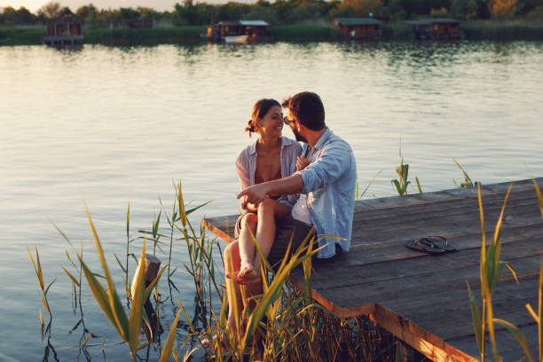 Young loving couple enjoys by the river during the sunset