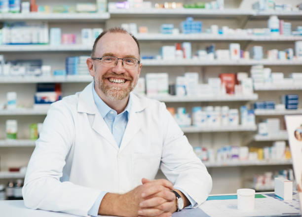 istock Mature male pharmacist smiles in greeting 1135487980