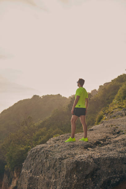 istock Sportsman making pause after workout on a tropical cliff. 1135488118