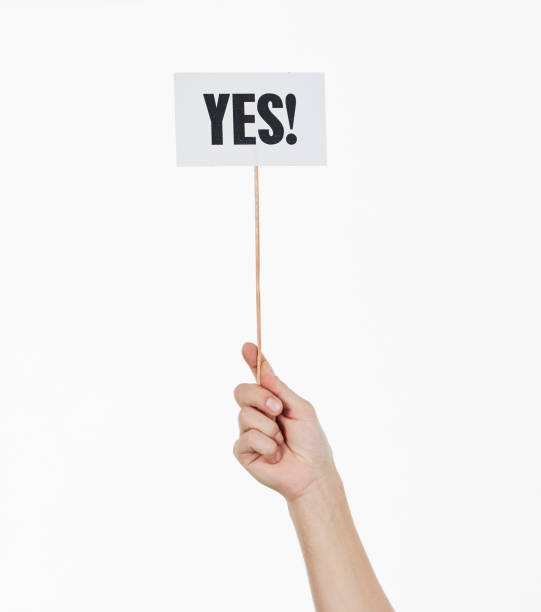 Single raised hand holds sign reading 
