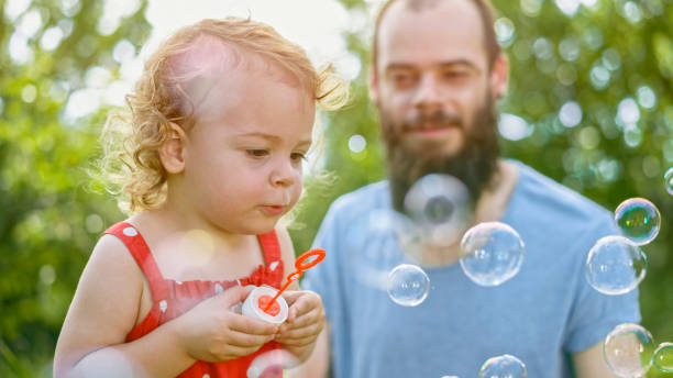 istock Little girl blowing soap bubbles 1135489077