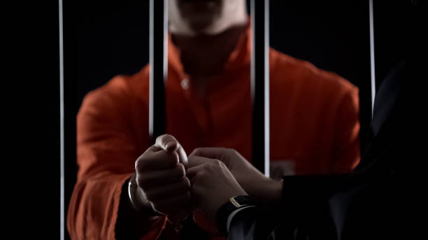 Guard taking handcuffs off criminal, releasing from jail due to good behavior Guard taking handcuffs off criminal, releasing from jail due to good behavior releasing stock pictures, royalty-free photos & images