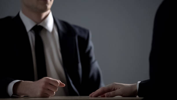 istock Businessmen sitting at table, making partnership agreement based on corruption 1135489411