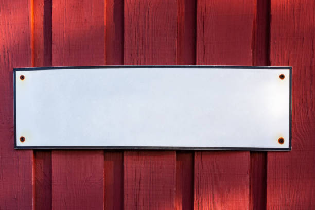 istock A white blank empty steel sign with copy space on a red wooden barn wall. 1135489445