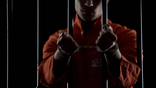 istock Convicted man showing handcuffs, standing behind prison bars, lawbreaking 1135489522