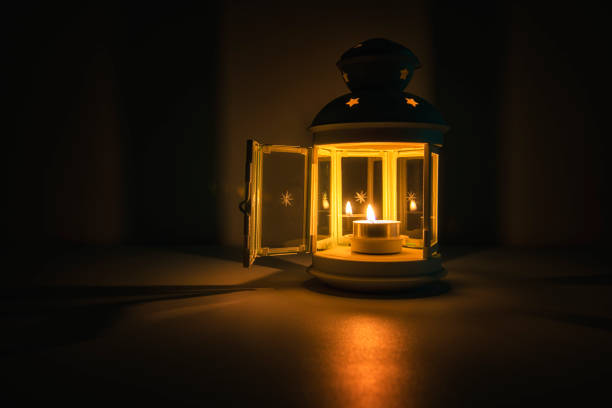 Golden lighthouse with a burning candle inside at night