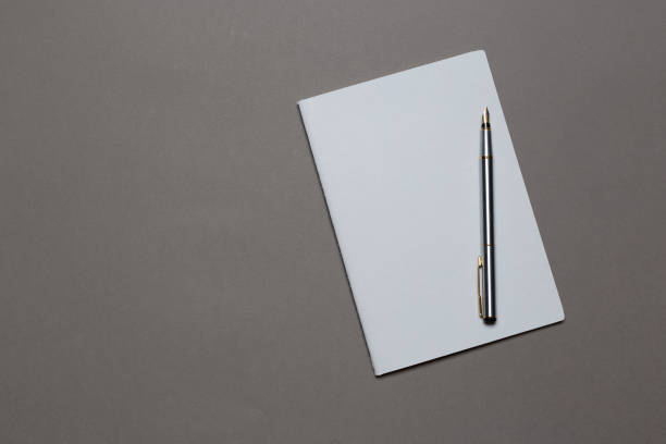 istock top view of a open notebook with pencil on a gray background. Office notepad flat lay 1135492319