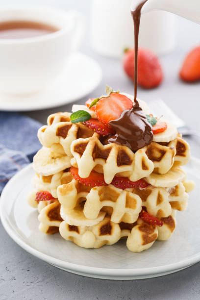 istock Stack of waffles with banana, strawberry and flowing chocolate. 1135496318
