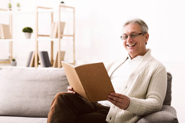 istock Mature man looking at photo album, having rest 1135496422
