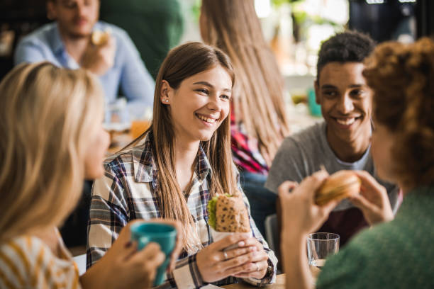 istock Group of college students talking while having lunch break at cafeteria. 1135496577