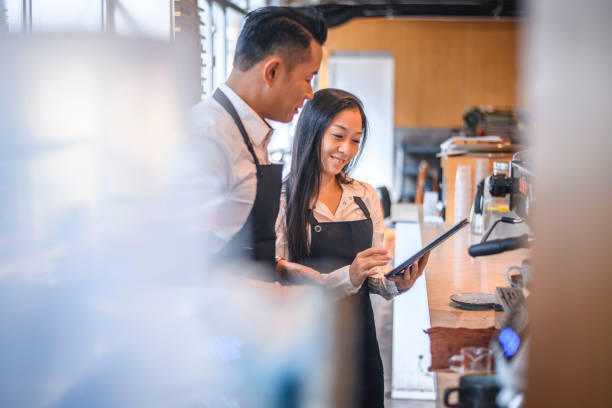 istock Baristas discussing over digital tablet in cafe 1135498543