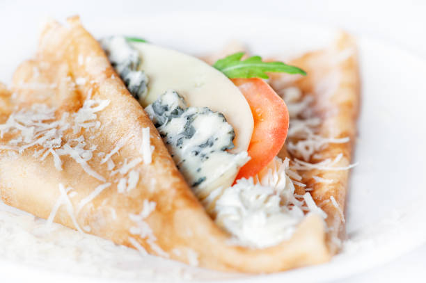 istock Thin delicious pancake with four types of cheese on white 1135498657