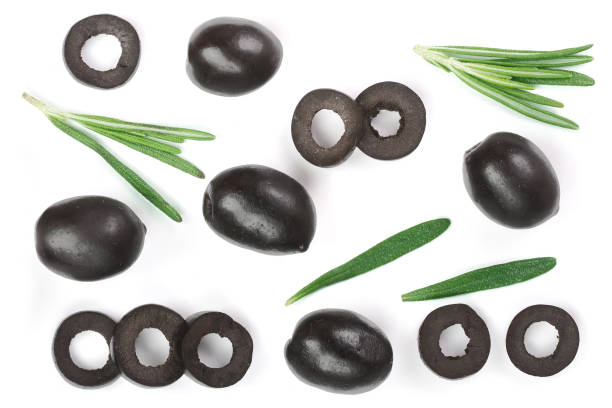 whole and sliced black olives with rosemary leaves isolated on white background. Top view. Flat lay pattern whole and sliced black olives with rosemary leaves isolated on white background. Top view. Flat lay pattern. green olive fruit stock pictures, royalty-free photos & images