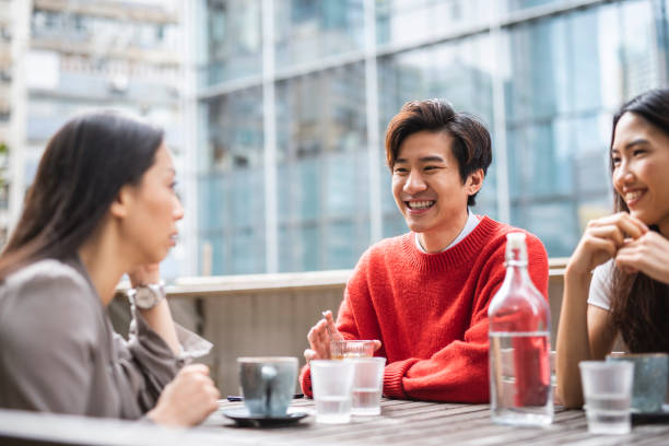 istock Three Chinese friends talking and drinking at a cafe 1135498914