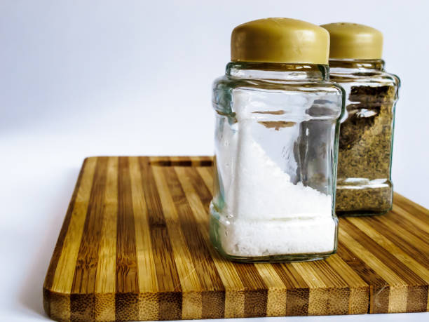 istock Salt and pepper in a glass shaker and pepper shaker stand on a cutting board 1135499032