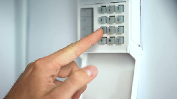 istock Man entering password on home security system, robbery protection, close up 1135499820