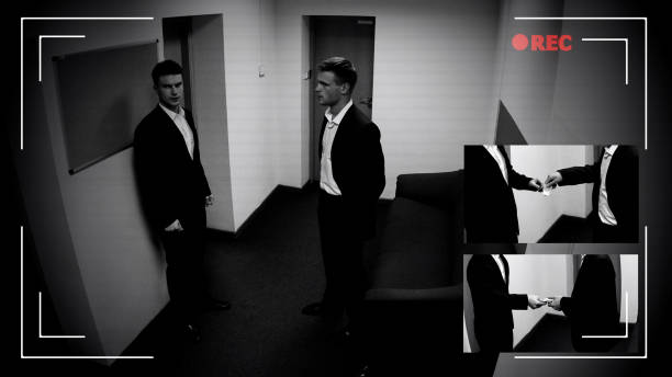 istock Young manager giving narcotics to co-worker, CCTV camera evidence, crime record 1135499842